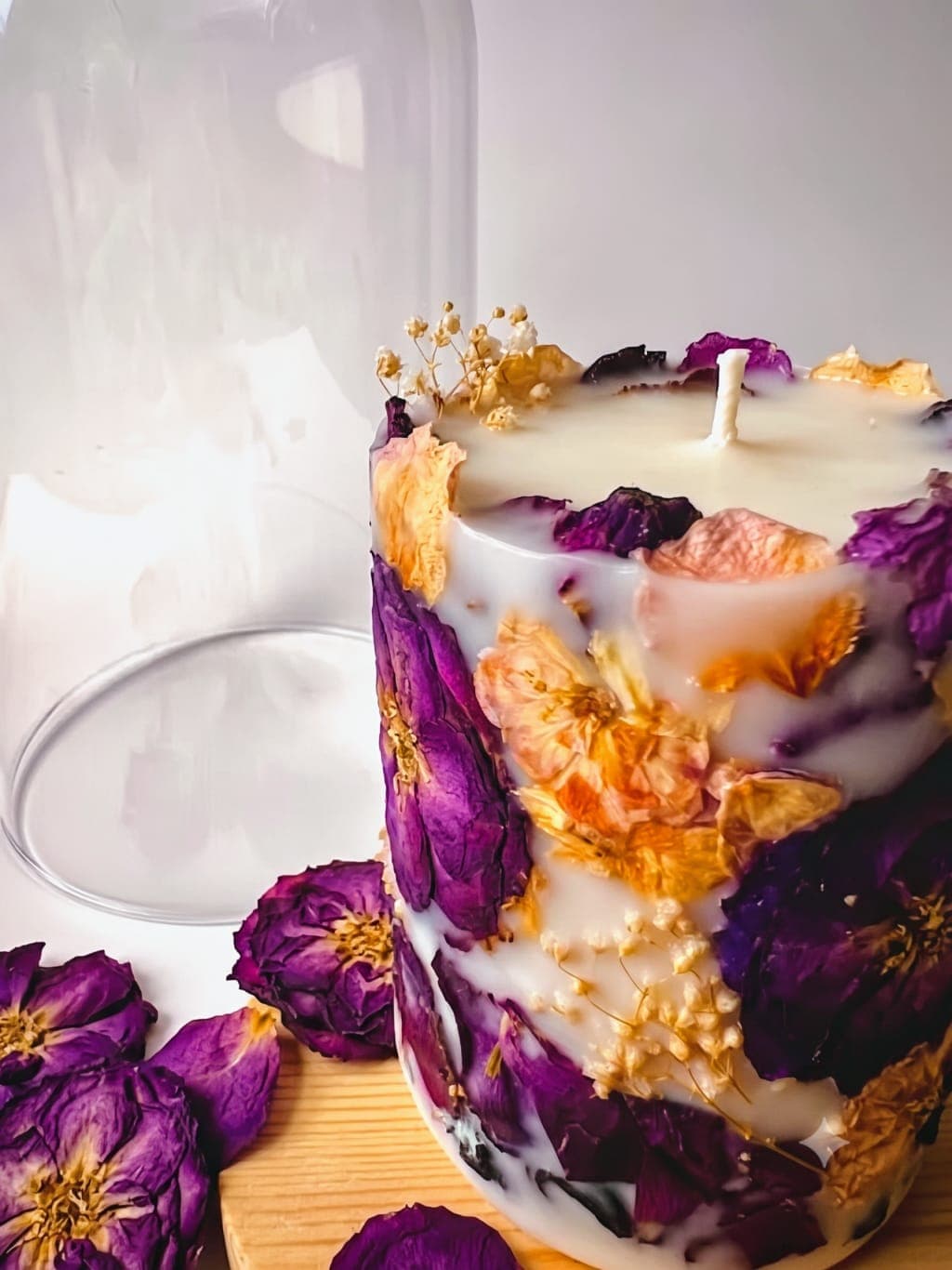 A Candera botanical candle with pressed rose petals and dried florals set in natural wax